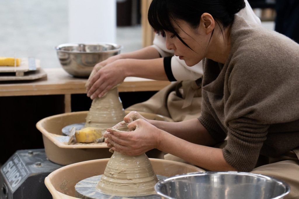 手捻り体験で粘土を形作る参加者の手元。世界にひとつだけの器を作成している様子。